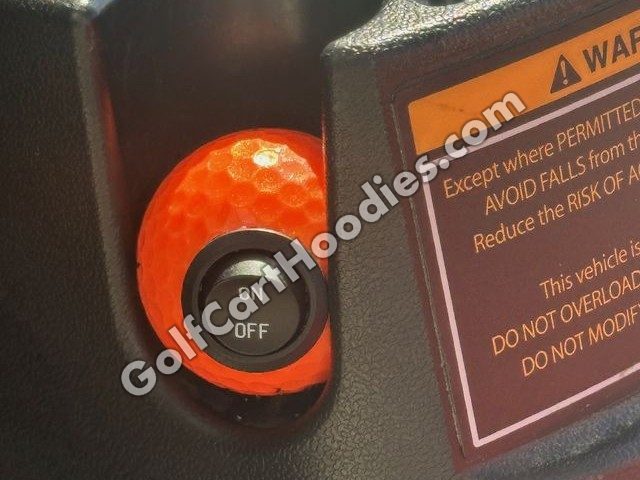 Orange golf ball on/off switch in a golf cart dash