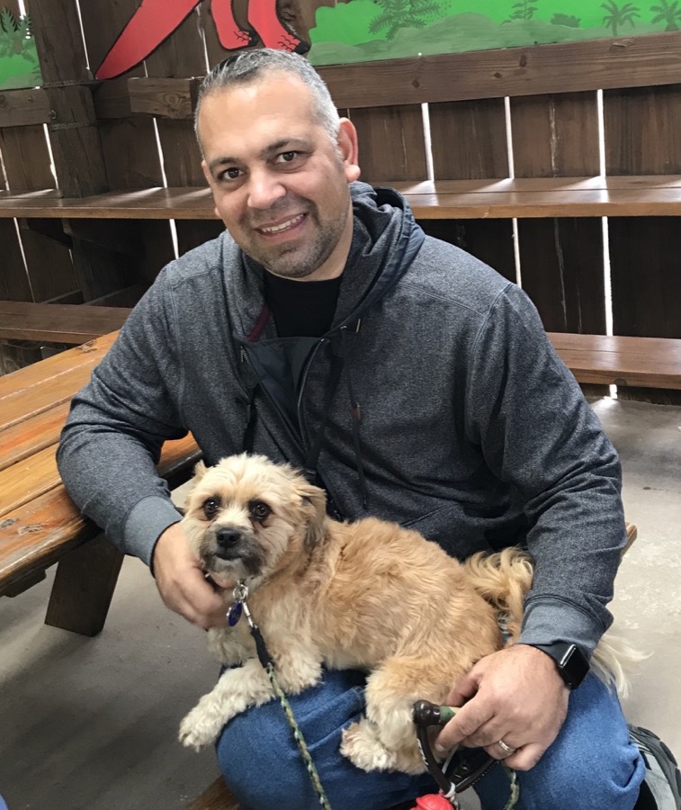 Richard Reed smiling with his dog Jack on his lap